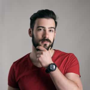 young man stroking touching beard looking at camera